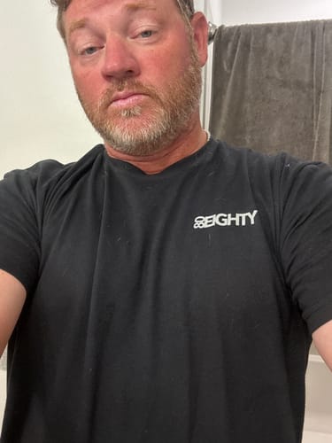 Close-up of a reviewer wearing the black 80Eighty® Limited Edition DCG89 Shirt.