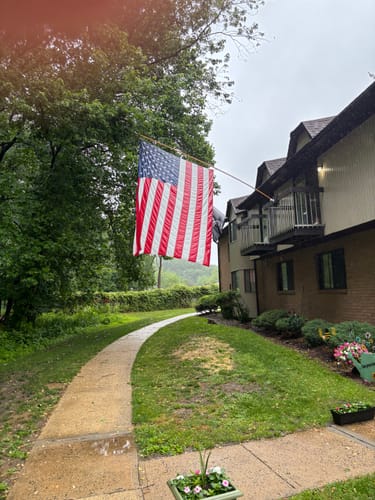Customer's Heavy Duty American Nylon Flag hanging from a pole on a rainy day.