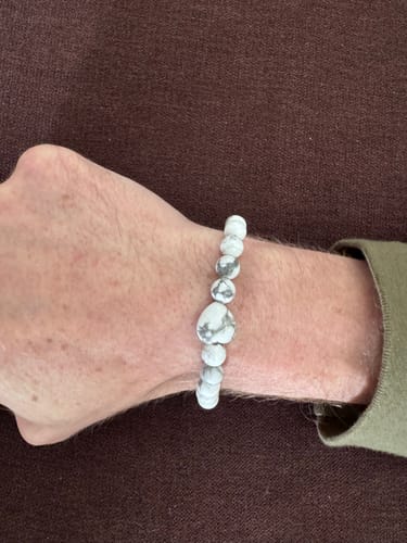 Customer wearing a white and grey marbled crystal bead bracelet on their wrist.