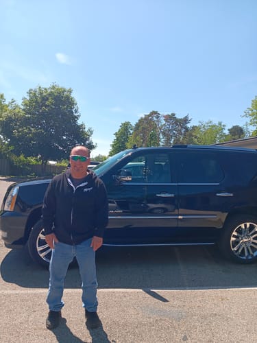 Customer wearing the black 80Eighty® Signature Zip Hoodie outdoors in front of a large black SUV.