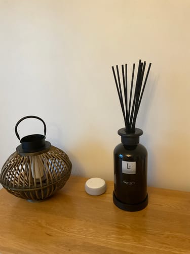 Customer's black Sable Onyx room diffuser with reeds on a wooden console.