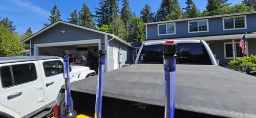 Customer's 5 Gallon Jugs, showing the blue spouts standing upright in the back of a truck.