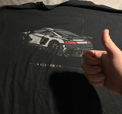 Reviewer gives a thumbs-up next to the car graphic on their black 80Eighty DCG89 shirt.
