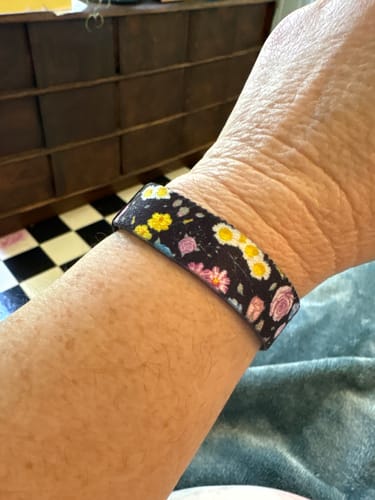 A reviewer wearing the dark, floral 'In a Field of Roses Bracelet' on their wrist.