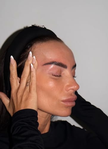Reviewer with eyes closed showing shiny, styled brows during the Cysteamine Brow Lamination Kit process.