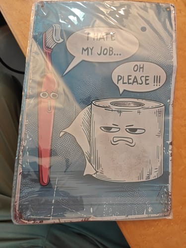 Customer's 'I Hate My Job Oh Please' funny wall art in its plastic packaging, showing a slight bend on the metal sign.