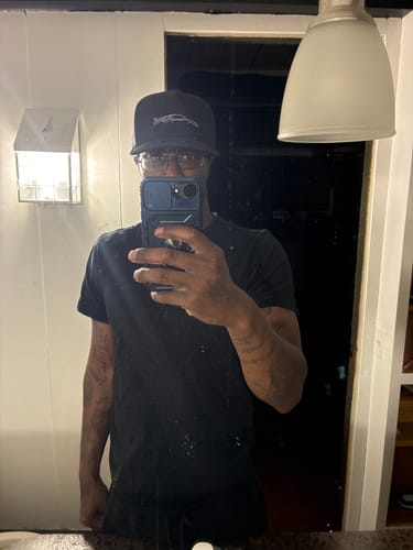 Reviewer taking a mirror selfie while wearing the black 80Eighty Limited Edition DCG89 Hat.