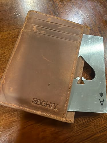 Customer's 80Eighty Cognac Leather Wallet on a table holding a metal ace of spades card.