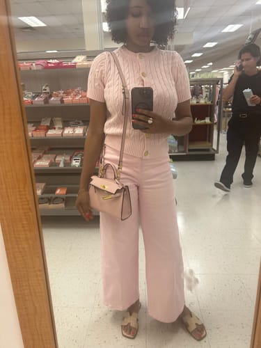 Customer taking a mirror selfie in a store, wearing the pink Kally Leather Bag crossbody with a matching outfit.