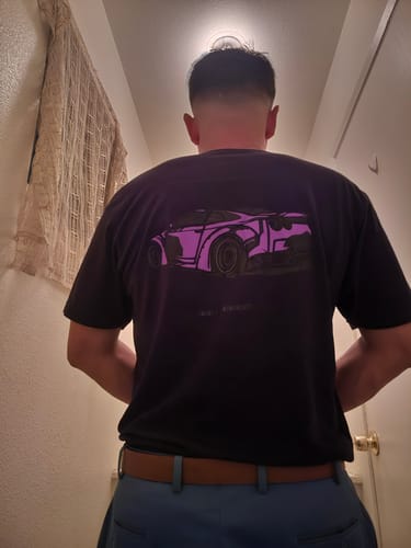 Reviewer from behind, wearing the black 80Eighty® Limited Edition DCG88 Shirt with a purple car graphic on the back.