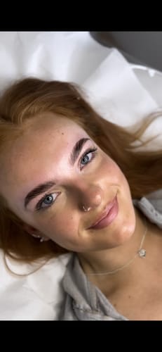 Customer smiling, showing the results of the Cysteamine Brow Lamination Kit with fuller, lifted eyebrows.
