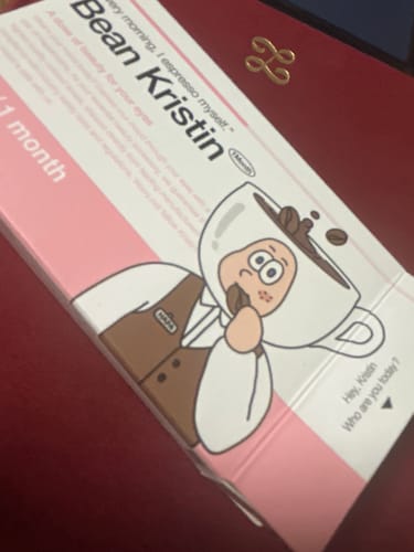 レビュアーの「Bean Kristin - ショートブラウン」のパッケージ。ピンクと白の箱が机の上に置かれています。