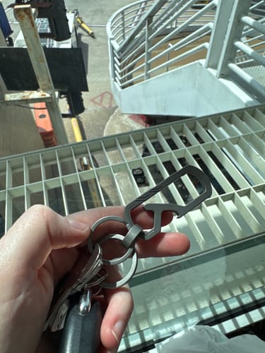 Customer holding their 80Eighty Titanium Keychain Clip with several keys and a car fob attached.
