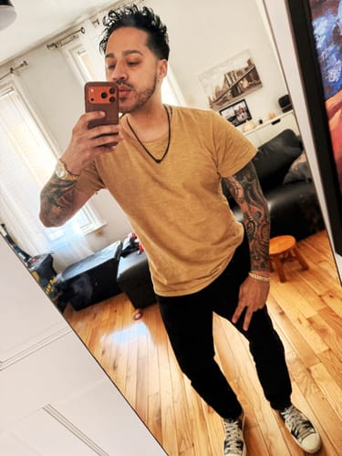 Reviewer taking a mirror selfie while wearing the black cord Legacy necklace.