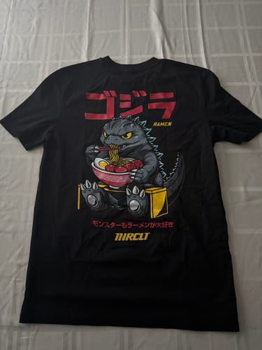 Customer's black RAMEN MONSTER TEE laid flat, showing the graphic of a monster eating ramen.