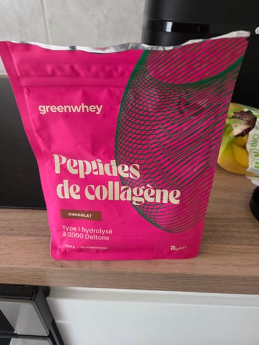 Sachet rose de Peptides de Collagène au chocolat d'un client, posé sur un comptoir de cuisine.
