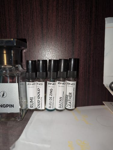 Customer's Make Your Own Tester Pack showing five small fragrance vials with white labels on a wooden surface.
