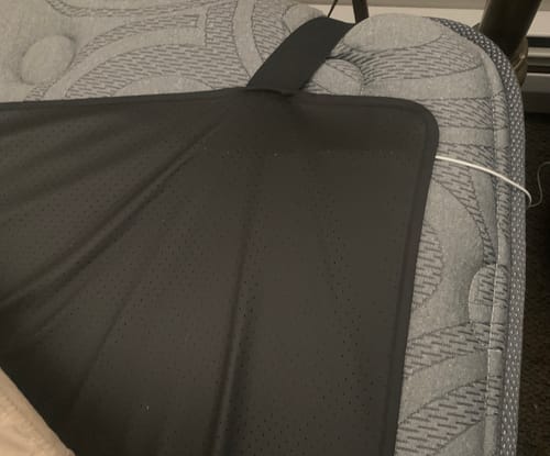 Customer's black Earthbound Grounding Mattress Pad with its corner strap fitted onto a mattress.