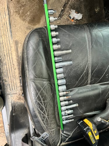 Customer's green Magnetic Aluminum Socket Rail with various sockets attached, resting on a black leather seat.