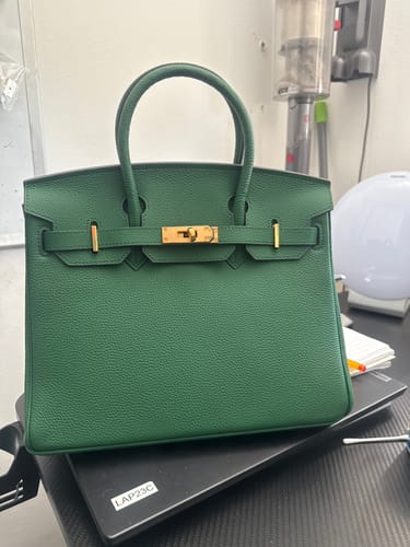 Customer's deep green, textured LALUVA Warkin Bag with gold hardware, sitting on a desk.