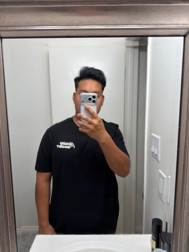 Customer taking a mirror selfie to show the fit of their black MORNING BOOST TEE.