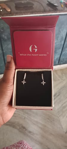 Customer holding the open red box, displaying the Silver Zircon Floret Drop Earrings inside.