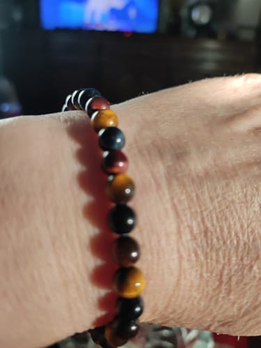Gros plan sur le Bracelet « Oeil Multiple » en pierres colorées porté au poignet d'un client.