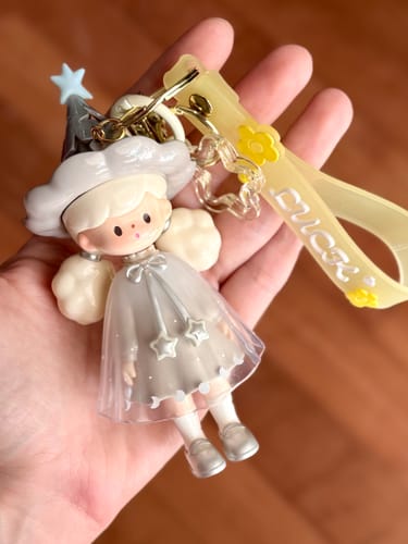 Customer holding the KikaGoods Handmade Keychain, showing a close-up of the cute figurine with a starry hat.