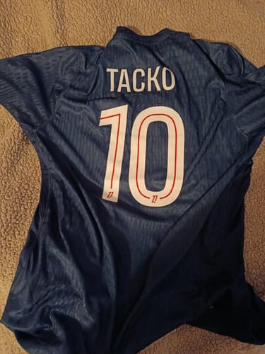 Vue arrière du maillot du PSG d'un client, personnalisé avec le nom 'TACKO' et le numéro 10.