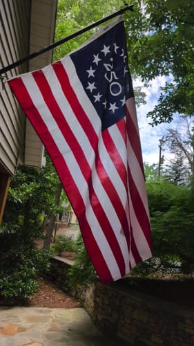Customer's America 250™ Betsy Ross Flag hanging from a flagpole attached to the side of a house.
