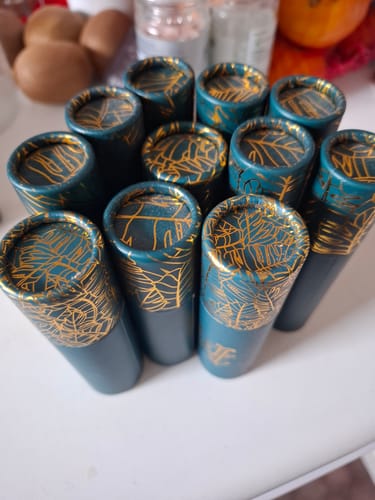 Customer's collection of teal travel-size Copacabana perfume tubes with gold-leaf patterns.