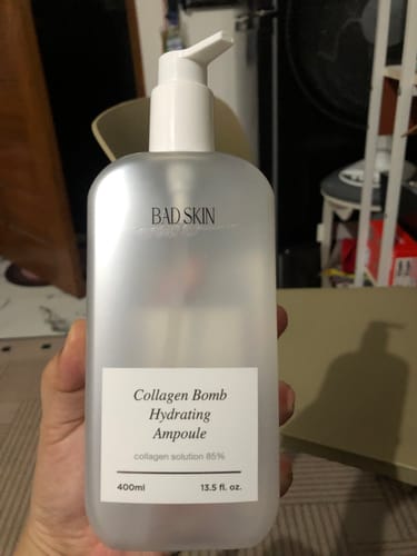 Customer holding the large frosted bottle of Bad Skin Korean Collagen Bomb Hydrating Ampoule.