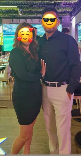 Customer wearing the black, ruched Kuria Long Sleeve Mini Dress at a restaurant.