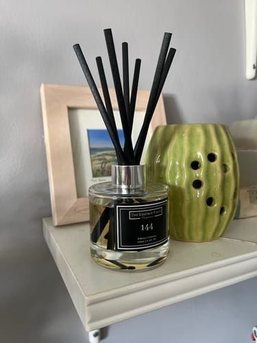 Customer's Reed Diffuser from the Essentials Bundle, displayed with black reeds on a shelf at home.