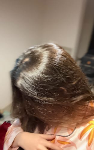 Una clienta muestra su cabello oscuro y brillante después de usar la Henna Jamila Hair.