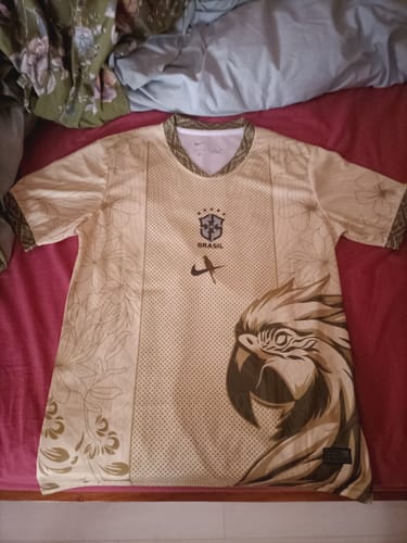 Un client montre son maillot spécial Brésil bird beige, posé à plat et montrant le grand graphique d'un oiseau.