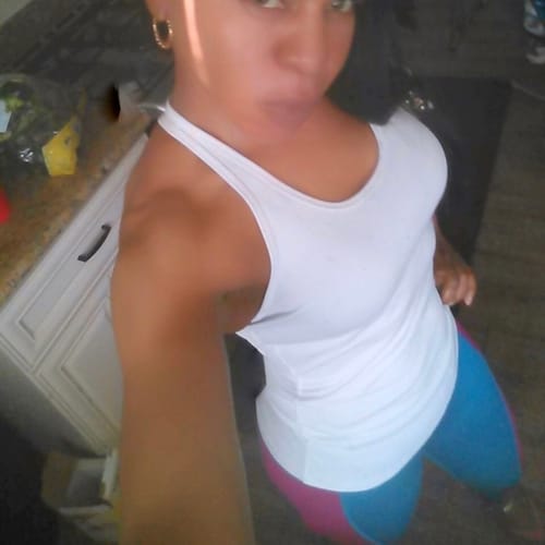 Reviewer in a white tank top taking a selfie, showing their fitness results from Cleanform Birds of Prey.