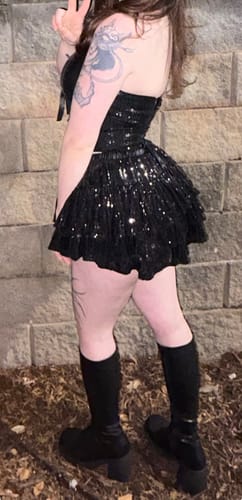 Partial view of a reviewer from the side wearing the black Onyx Fairydust Sequin Matching Set and boots.