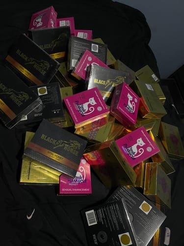 Cliente muestra un gran montón de varias cajas de productos de miel apiladas sobre una tela oscura.