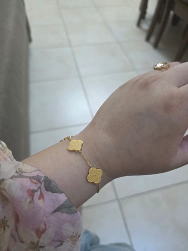 Customer wearing the gold Sabr, Shukr, Tawakkul Bracelet with clover-shaped charms on their wrist.
