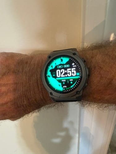 Reviewer's Gard Pro Ultra 3 watch on their wrist with a bright, green hiker-themed face.
