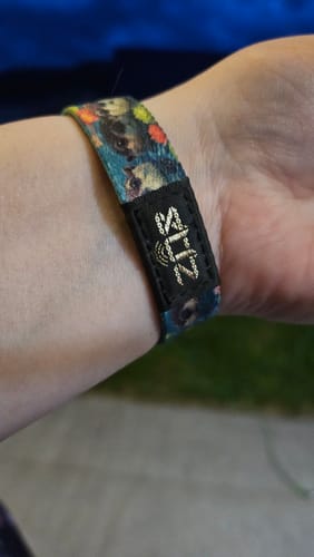 Close-up of a customer's wrist wearing the colorful Otterly Adorable Bracelet with its cute otter pattern.
