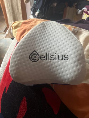Gros plan sur le coussin orthopédique pour genoux Cellsius d'un client, montrant sa surface blanche et texturée avec le logo.