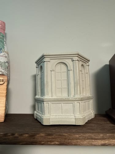 Reviewer's architectural Monument cement vessel displayed on a dark wooden shelf.