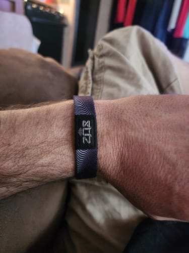Close-up of a customer's wrist wearing the dark, patterned Serenity Courage Wisdom Bracelet.