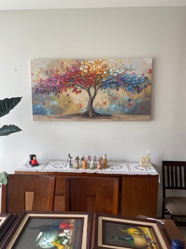 El cliente muestra el cuadro Árbol despertar de aves colgado en la pared de su sala de estar.