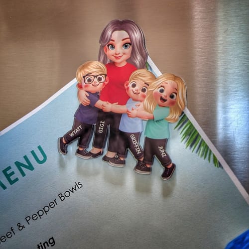 Customer's adorable personalized acrylic magnet of a grandma and three grandkids hugging, displayed on a refrigerator.