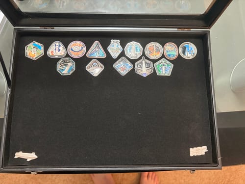 Customer displays their complete collection of Starship pins, including the new Flight 4 pin, inside an open black display box.