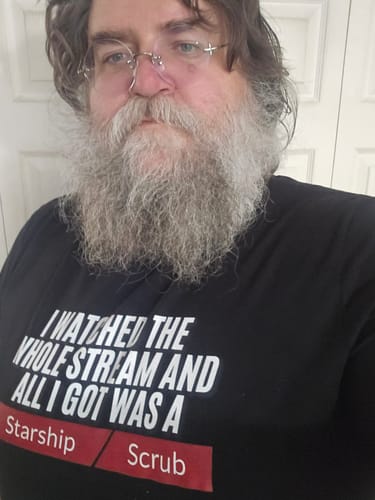 Reviewer wearing the black graphic Starship Scrub T-shirt, showing off the fit and design.