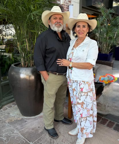 Reviewer wearing the printed Retro® Vintage Maxi Dress with a white jacket and matching cowboy hat.